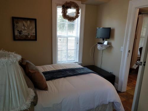 KingsvilleHellemsfield Inn & bed and breakfast的一间卧室,配有一张带花圈的床铺,窗户上