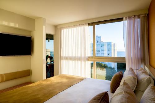 蒙得维的亚欧文蒙得维的亚酒店的一间卧室设有一张大床和大窗户