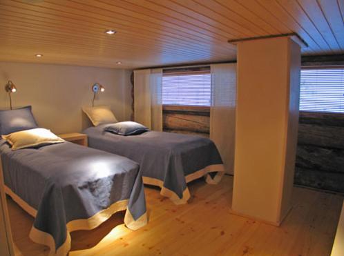 鲁卡凯鲁科多小木屋酒店的一间卧室设有两张床和窗户。