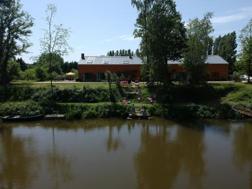 夫洛雷恩Florennes Gîte neuf 150 M2 devant un grand lac privé de 2 hectares poissonneux au milieu des bois的一群人坐在河里的船上