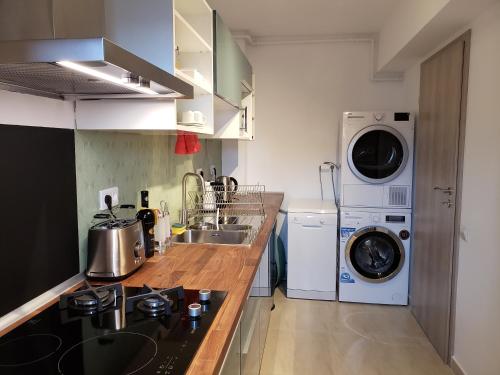 布加勒斯特Urban Nest Apartment的厨房配有洗衣机、洗衣机和烘干机。