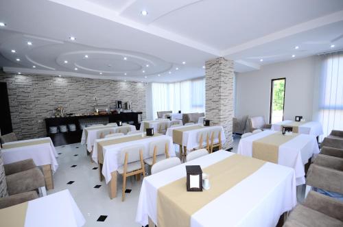 巴统Dream Tower的餐厅设有白色的桌椅和壁炉