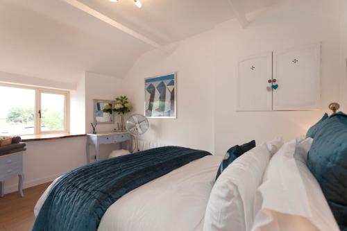 格兰瑟姆Vale View Barn的白色的卧室设有床和窗户