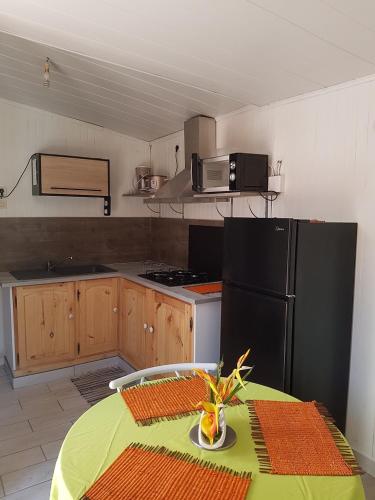 锡拉奥Le Moutardier 2的厨房配有桌子和黑冰箱。