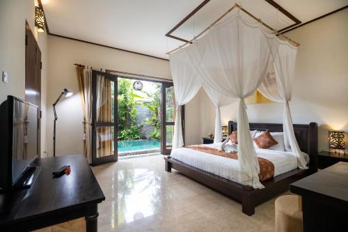 塞米亚克巴厘阿玉酒店&别墅的一间卧室设有天蓬床和游泳池