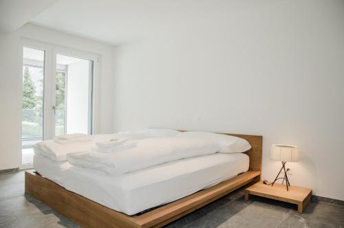因特拉肯Apartment JungfrauCenter Schynige Platte - GriwaRent AG的卧室内的一张白色的木架床