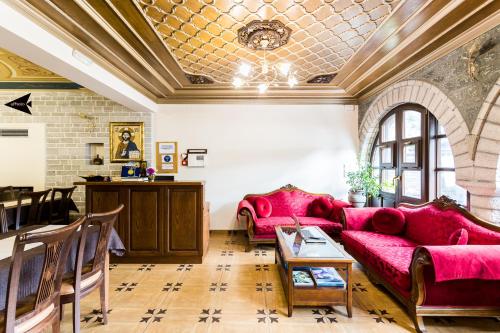 切佩洛沃帕罗拉亚别墅旅馆的客厅配有红色的沙发和桌子