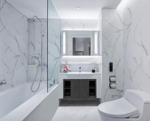 曼谷Somerset Maison Asoke的白色的浴室设有水槽和淋浴。
