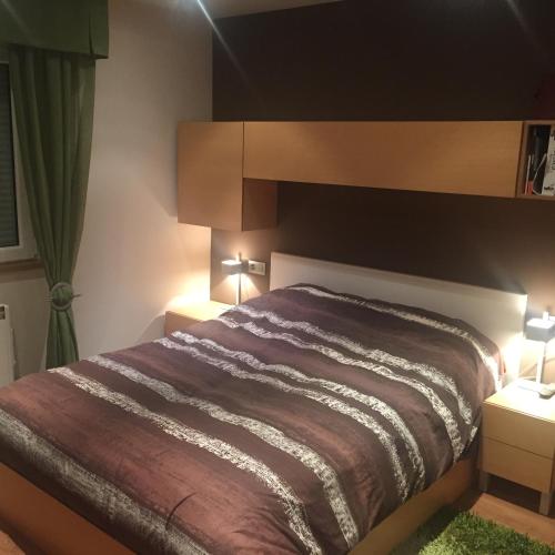 蓬费拉达Bierzo centro的一间卧室配有一张带2个床头柜和2盏灯的床。