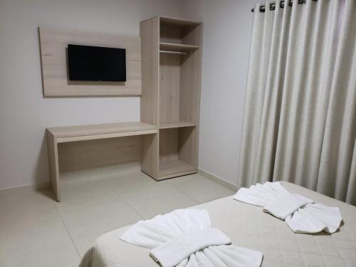 奥兰布拉Villa de Holanda Parque Hotel的一间卧室配有带毛巾的床