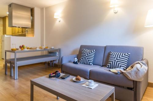 埃尔塔特Pierre & Vacances Andorra Alba的客厅配有蓝色的沙发和桌子