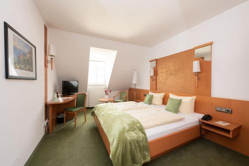 比特堡碧特博格霍夫酒店的酒店客房设有一张大床和一张书桌。