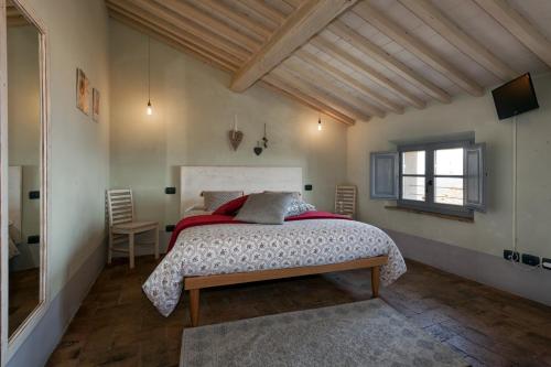 蒙塔尔奇诺梯子广场住宿加早餐旅馆的一间卧室设有一张大床和一个窗户。
