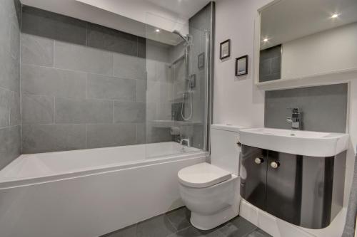 惠特比38 George Street的浴室配有盥洗盆、卫生间和浴缸。
