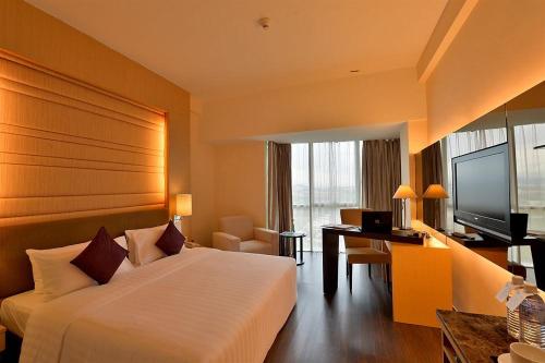哥打京那巴鲁婆罗洲柯乐艮摄政1号酒店的酒店客房配有一张床、一张书桌和一台电视。