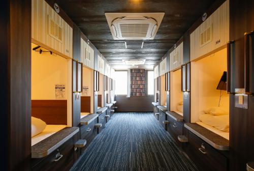 广岛起居室胶囊旅馆的走廊上,房间里有一排床