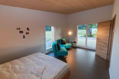 TramelanAu Chant du Vent的一间卧室配有一张床、一把椅子和窗户。