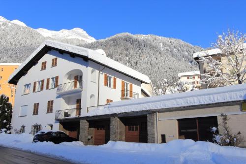 艾罗洛Chalet Cuore delle Alpi的一座被雪覆盖的建筑,背景是一座山