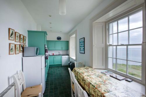 DonoureGalley Head Lightkeeper's Houses的厨房配有绿色橱柜和白色冰箱
