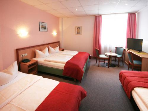 特里尔Hotel Constantin的酒店客房配有两张床和一张书桌