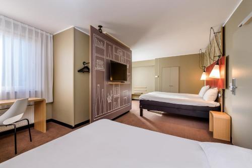 里尔里尔中心大广场宜必思酒店的一间酒店客房,设有两张床和电视
