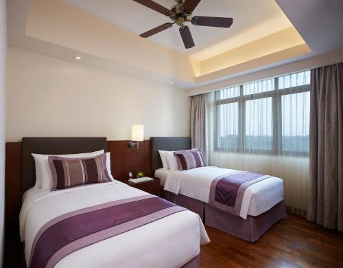 仰光Shangri-La Serviced Apartments, Yangon的酒店客房配有两张床和吊扇。