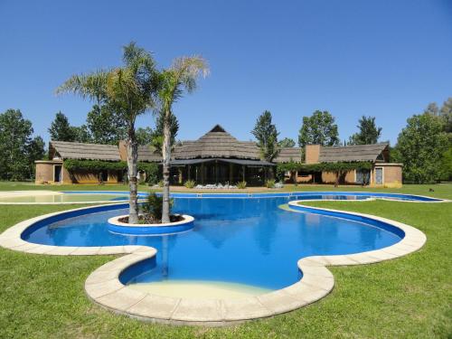 圣达菲Solares de la Laguna的一座房子前面的游泳池,上面有棕榈树