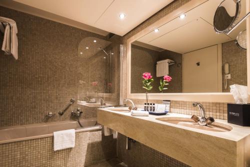 蒙特勒Royal Plaza Montreux的浴室设有2个水槽、浴缸和镜子