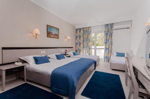 甘达坞伊港El Mouradi Club Selima的酒店客房设有两张床和电视。