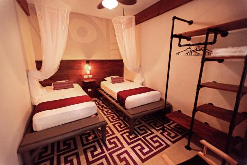 蒂卡尔蒂卡尔丛林旅舍的一间设有两张床的房间和一间带架子的房间