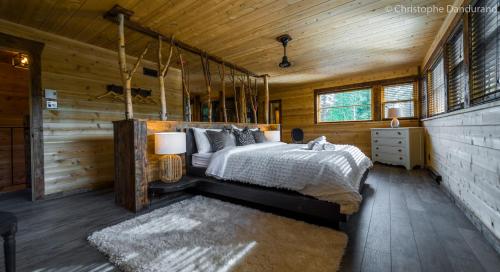 拉马巴耶Chalet TAO par Les Chalets Spa Canada的小木屋内一间卧室,配有一张床