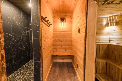 拉马巴耶Chalet TAO par Les Chalets Spa Canada的小木屋设有木墙和桑拿浴室