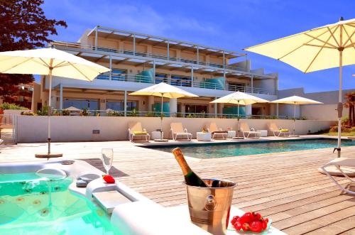 利勒鲁斯凯里公寓酒店的游泳池畔的餐桌上提供一瓶葡萄酒