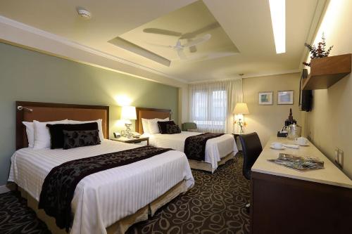 萨卡特卡斯阿萨卡特卡斯帝王酒店的酒店客房配有两张床和一张书桌