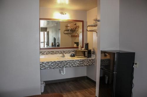 BrookelandRayburn Inn的一间带水槽和镜子的浴室以及一台冰箱