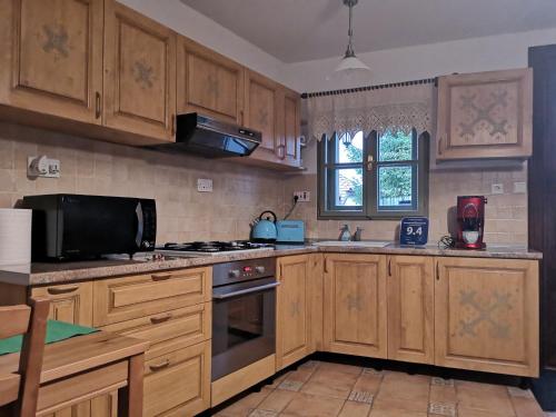 布拉索夫Drumul Poienii Apartment的厨房配有木制橱柜和炉灶烤箱。