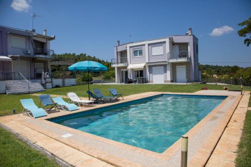 克里皮吉Dream Villa 2的一个带椅子的游泳池以及一座房子