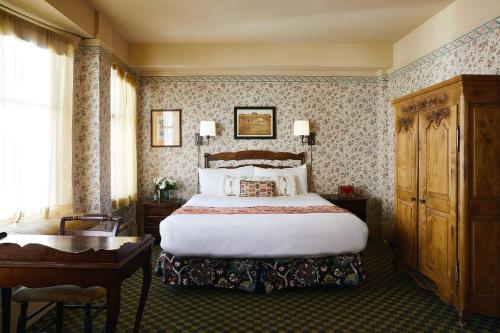 旧金山贝提特旅馆的酒店客房配有一张床、一张书桌和一张四柱床