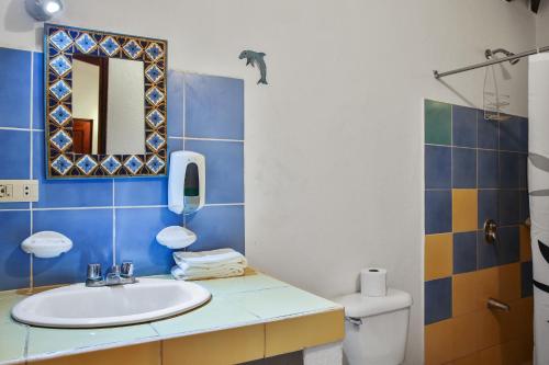 塔马林多马孔多别墅的一间带水槽、镜子和卫生间的浴室