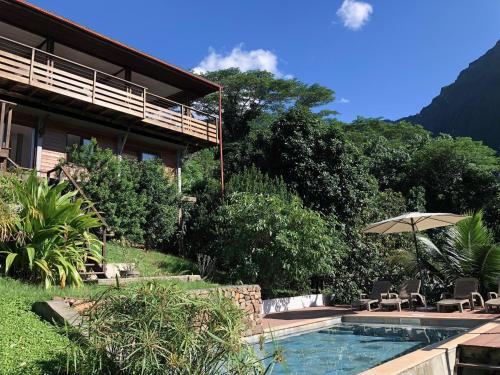 TeavaroLa Villa Te Fetia Nui Moorea的一座带游泳池和遮阳伞的房子