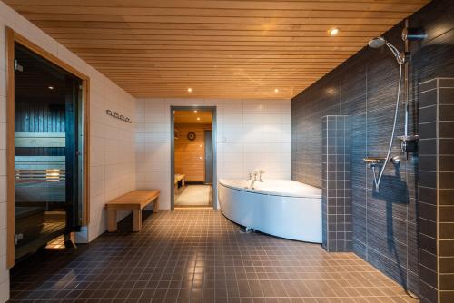 鲁卡Rukavuorenhuippu Apartment的大型浴室设有浴缸和淋浴。