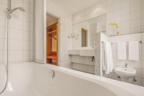 爱尔福特埃克塞西奥贝斯特韦斯特普拉斯酒店 的带浴缸、水槽和镜子的浴室