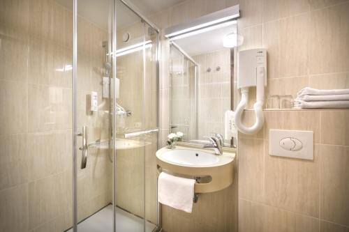 洛帕San Marino Resort的一间带水槽和玻璃淋浴的浴室