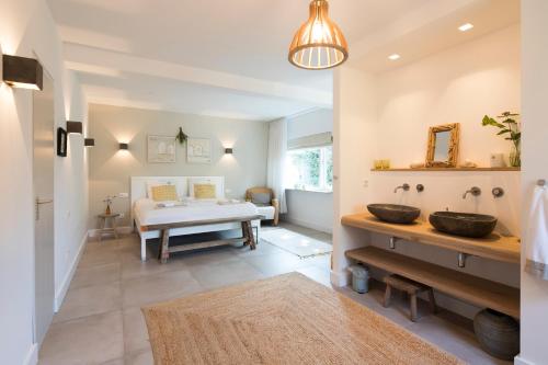 MoergestelHet Ockhuis的一间带水槽的浴室和一张位于客房内的床