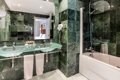 科尔多瓦艾可思拉斯阿德尔法斯酒店的浴室配有绿色水槽和浴缸。