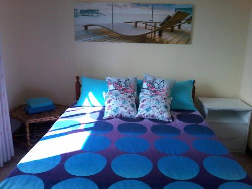 阿尔比恩Chez Cozy's的一间卧室配有蓝色和蓝色枕头的床