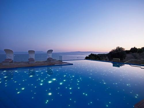 帕诺尔莫斯斯科派洛斯阿德里纳度假酒店和Spa中心的黄昏时可欣赏到海景的游泳池