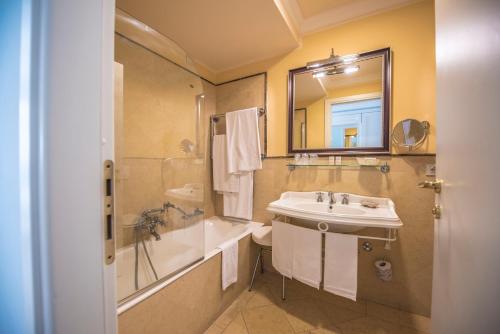 贾迪尼-纳克索斯达芙妮别墅酒店的一间带水槽、浴缸和镜子的浴室