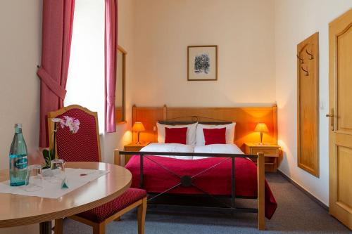萨尔堡维茨豪斯费得马克酒店的酒店客房配有床、桌子和桌子。