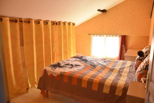 Saint-TrojanMaison dans le vignoble de Bordeaux-Blaye-Bourg-CNPE的一间卧室配有床和带窗帘的窗户